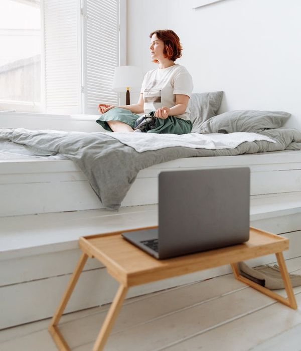 Woman practicing yoga in a bright, minimalist interior.